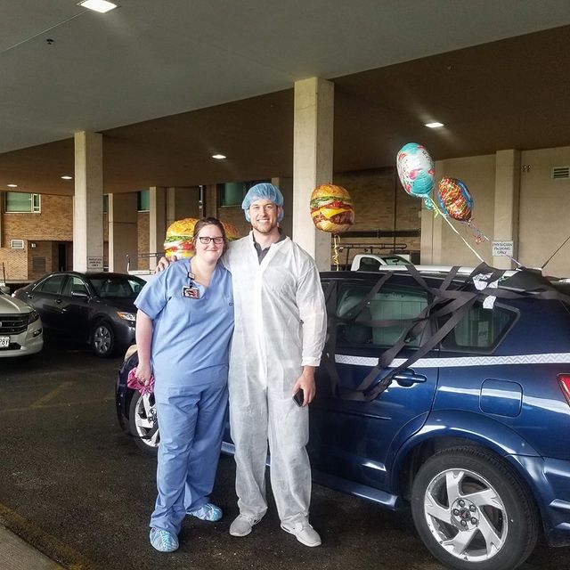Clayton Echard in front of his car in a white PPE.